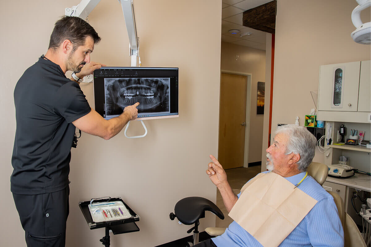 Dr. Pocock speaking with a patient while pointing at dental x-rays at Pocock Family Dental in Twin Falls ID.